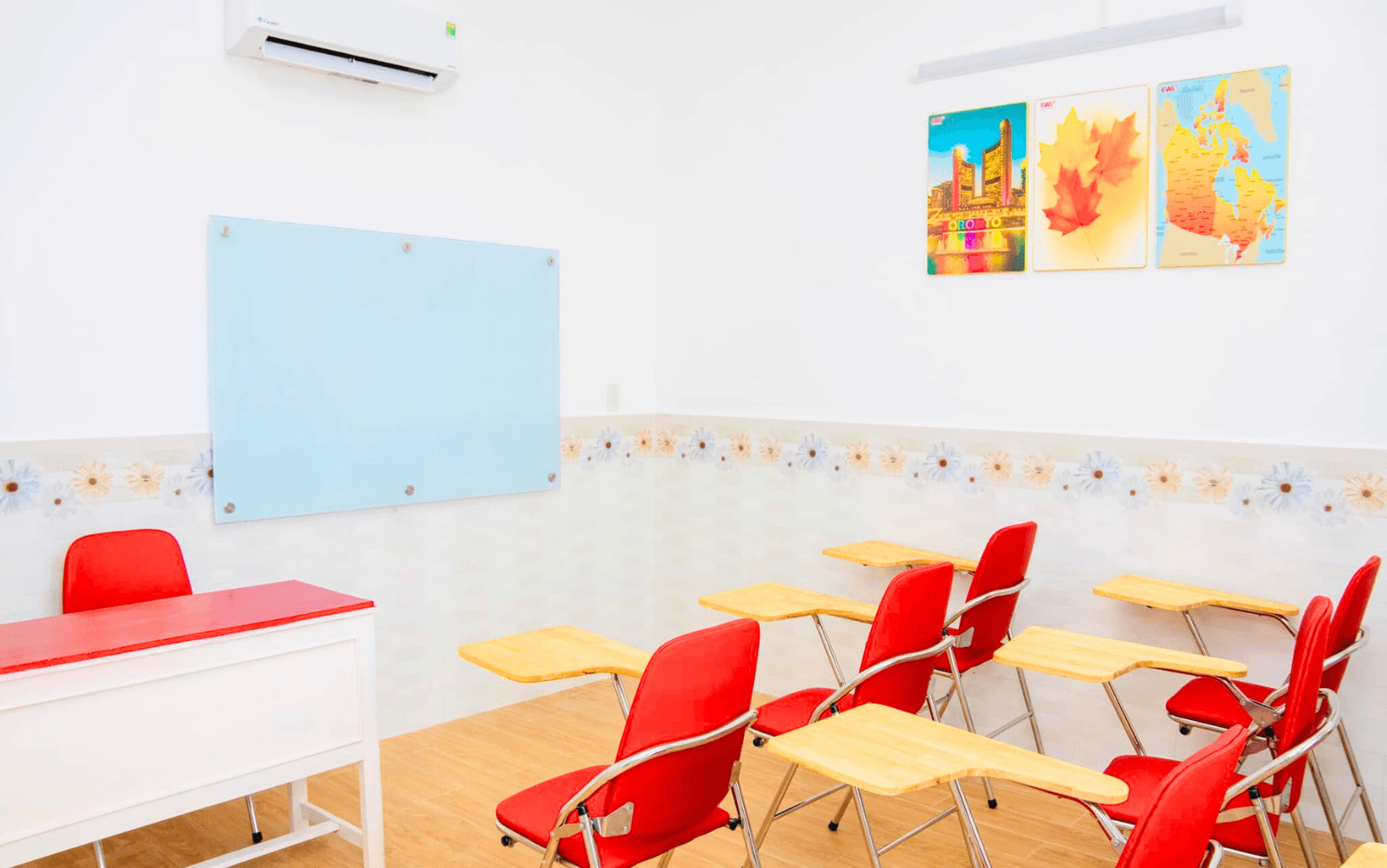 Phòng học Cambridge tại Âu Việt Úc với bàn ghế đỏ và bảng kính